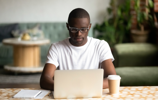 Man in glasses studying on a laptop